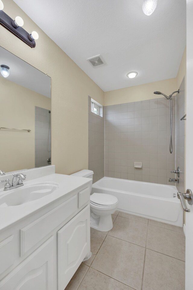 full bathroom with toilet, tiled shower / bath combo, vanity, and tile patterned flooring