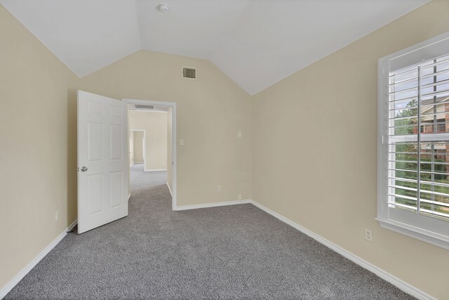 unfurnished bedroom featuring lofted ceiling and carpet floors