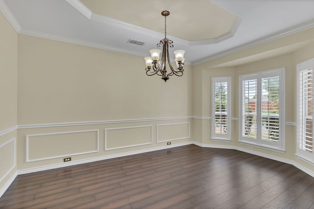 empty room with a notable chandelier, dark hardwood / wood-style floors, ornamental molding, and a tray ceiling