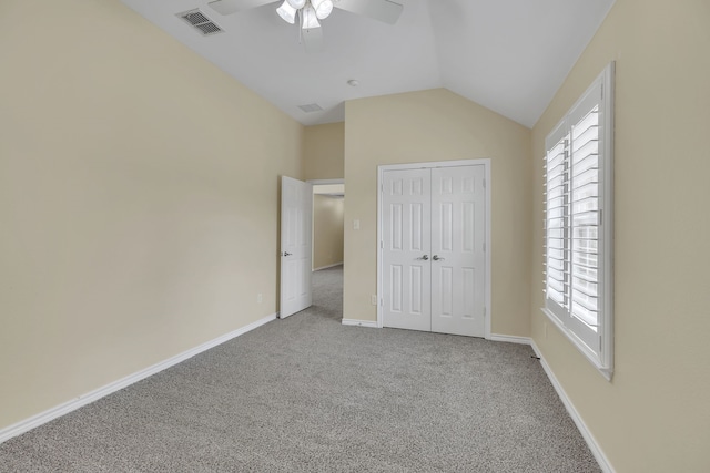 unfurnished bedroom featuring ceiling fan, a closet, lofted ceiling, and carpet floors