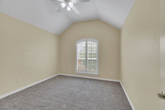 carpeted spare room featuring ceiling fan and lofted ceiling