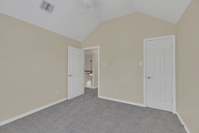 unfurnished bedroom featuring ceiling fan, vaulted ceiling, and carpet