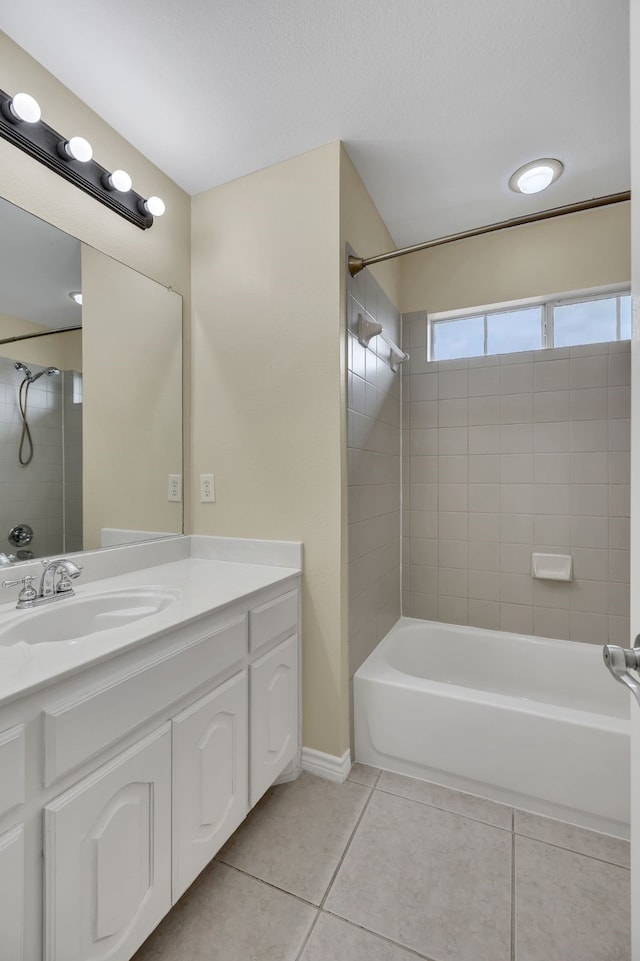 bathroom featuring tile patterned floors, vanity, and tiled shower / bath