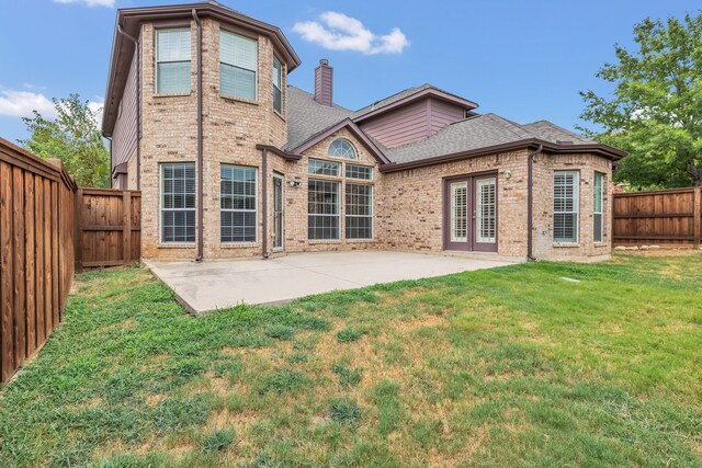 rear view of house featuring a lawn and a patio