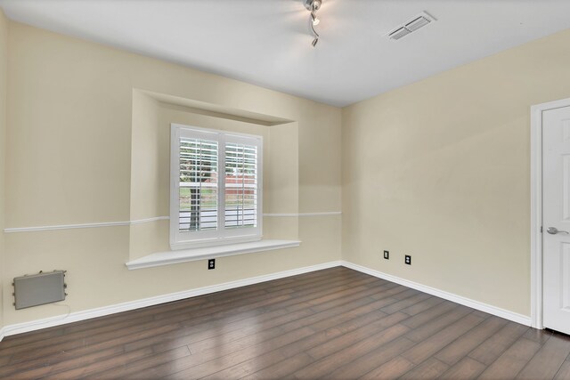 spare room featuring dark wood-type flooring and track lighting