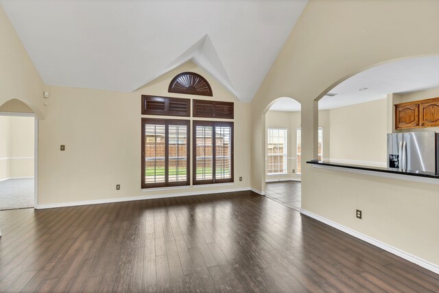 unfurnished living room with high vaulted ceiling, hardwood / wood-style floors, and a wealth of natural light