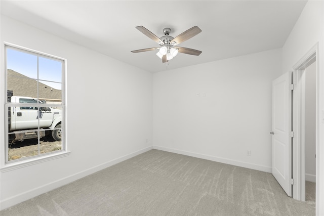 empty room with ceiling fan and light colored carpet