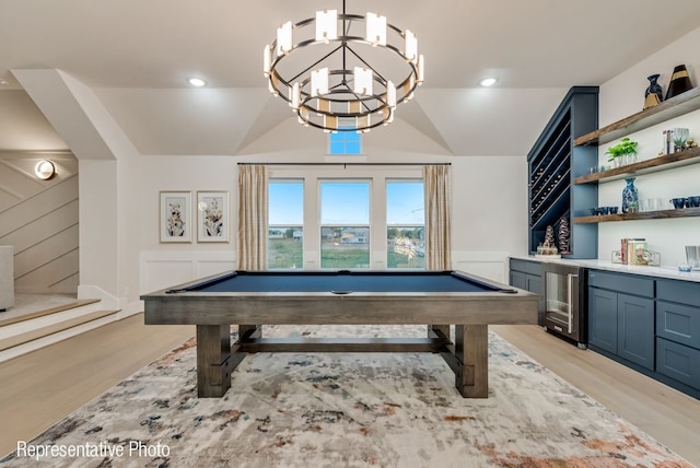 rec room with wine cooler, light wood-type flooring, a notable chandelier, and pool table