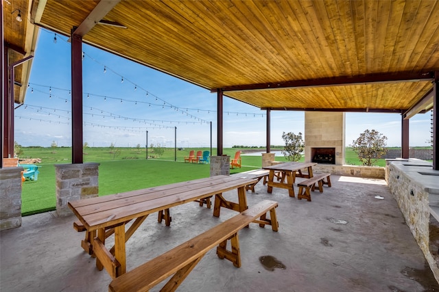 view of patio with ceiling fan and a fireplace