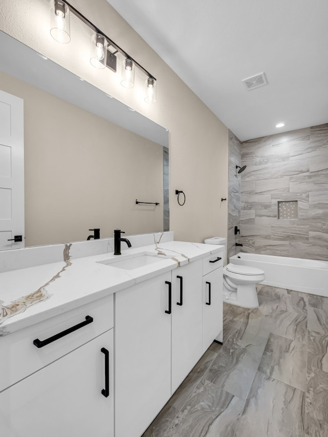 full bathroom featuring vanity, toilet, and tiled shower / bath