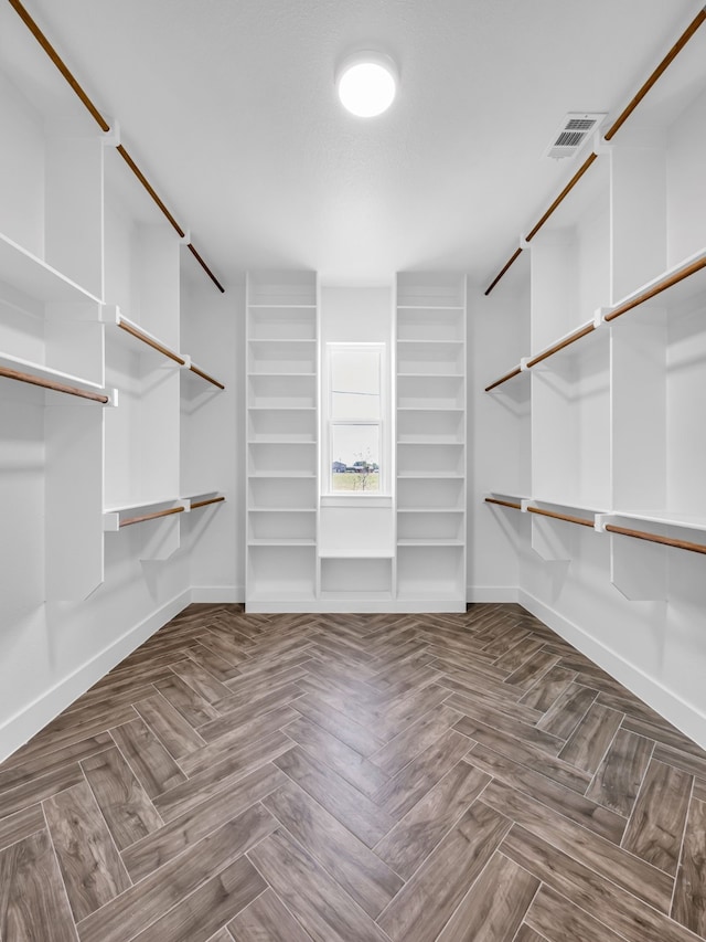 spacious closet featuring parquet floors