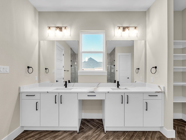 bathroom with walk in shower, vanity, and wood-type flooring