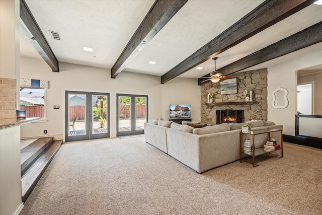 living room with light carpet, a fireplace, and beamed ceiling