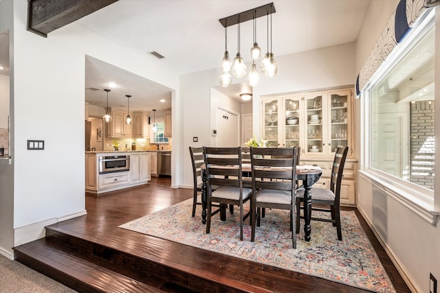 dining room with dark hardwood / wood-style floors and an inviting chandelier