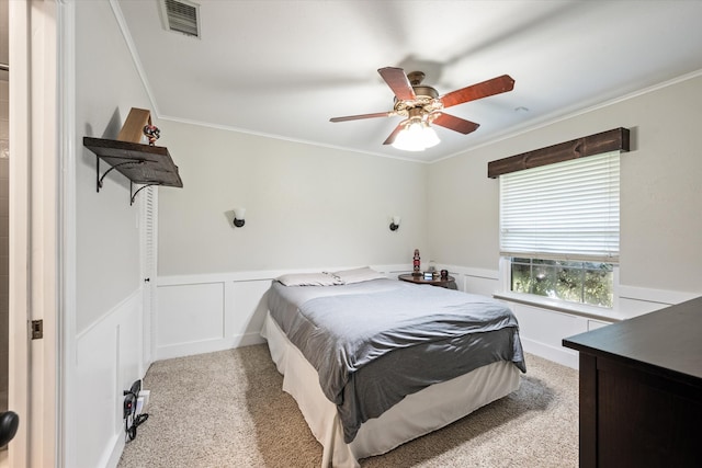 carpeted bedroom with ceiling fan and crown molding