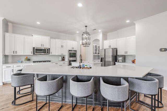 kitchen featuring light wood-type flooring, stainless steel appliances, and a large island