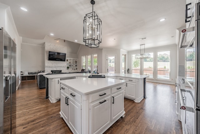 kitchen featuring a kitchen island, an inviting chandelier, kitchen peninsula, and dark hardwood / wood-style floors