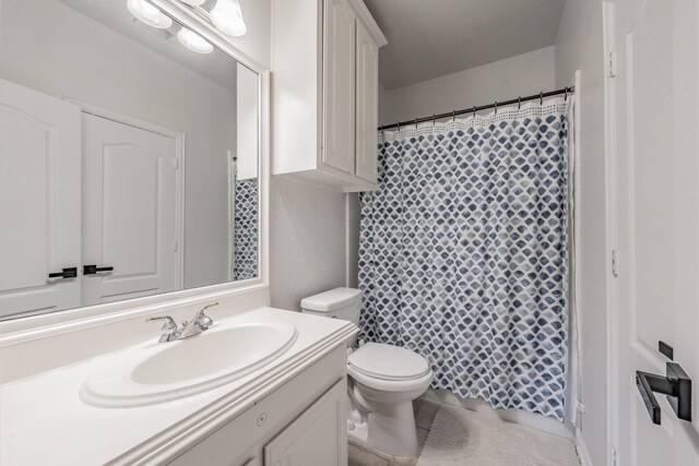 bathroom featuring toilet, vanity, and tile patterned floors