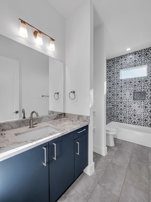 full bathroom featuring vanity, tiled shower / bath, and toilet