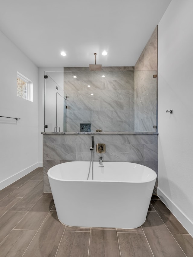 bathroom with separate shower and tub and tile walls