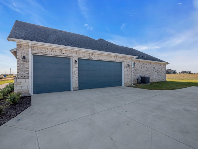 view of side of property featuring central AC and a garage