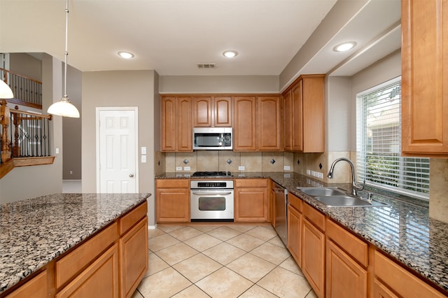 kitchen with stainless steel appliances, backsplash, light tile patterned floors, sink, and decorative light fixtures