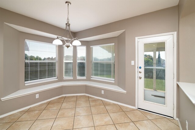 unfurnished dining area with a notable chandelier, light tile patterned floors, and a wealth of natural light