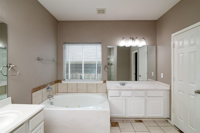 bathroom with double sink vanity, tile patterned floors, and a washtub