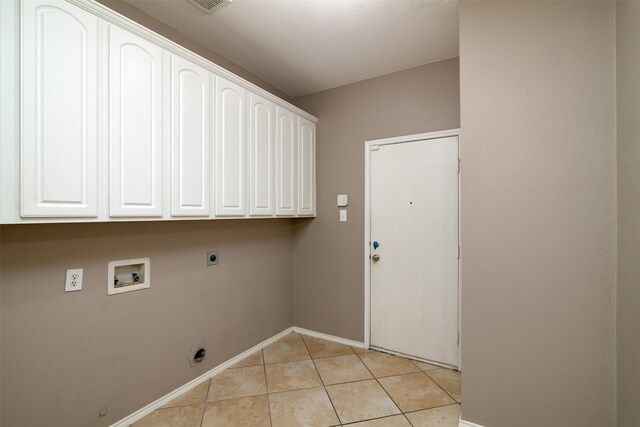 laundry room with electric dryer hookup, hookup for a washing machine, light tile patterned floors, and cabinets