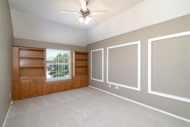 spare room featuring ceiling fan, vaulted ceiling, and light colored carpet