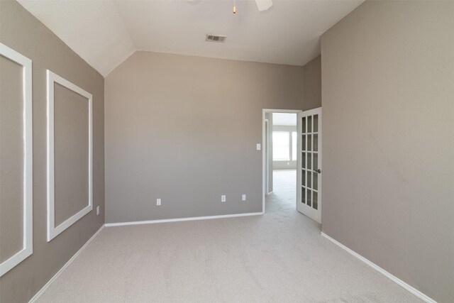 carpeted empty room with ceiling fan and vaulted ceiling