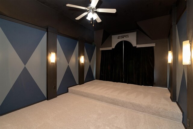 carpeted home theater room with ceiling fan