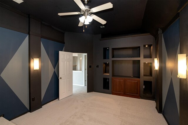 home theater room with ceiling fan and light carpet