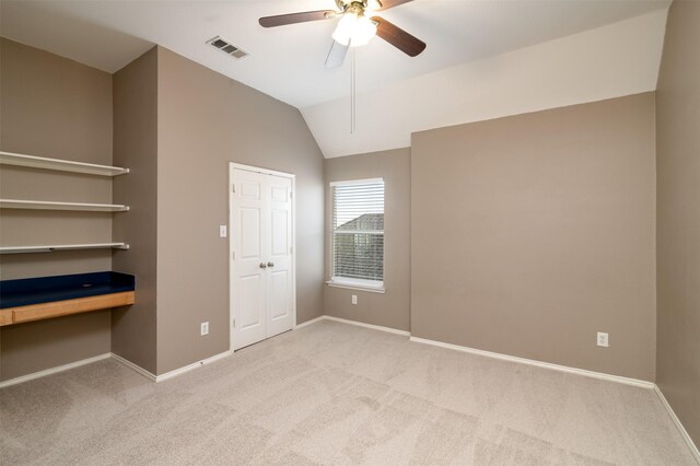 unfurnished bedroom featuring ceiling fan, vaulted ceiling, and light carpet