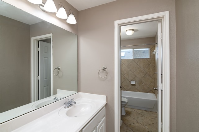 full bathroom featuring tile patterned floors, tiled shower / bath, vanity, and toilet