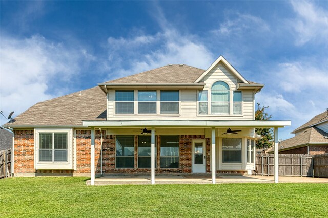 rear view of house featuring ceiling fan, a patio, and a yard