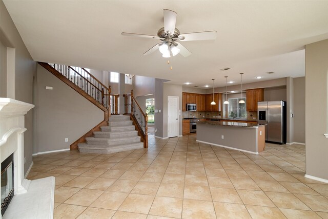 unfurnished living room featuring ceiling fan and light tile patterned flooring