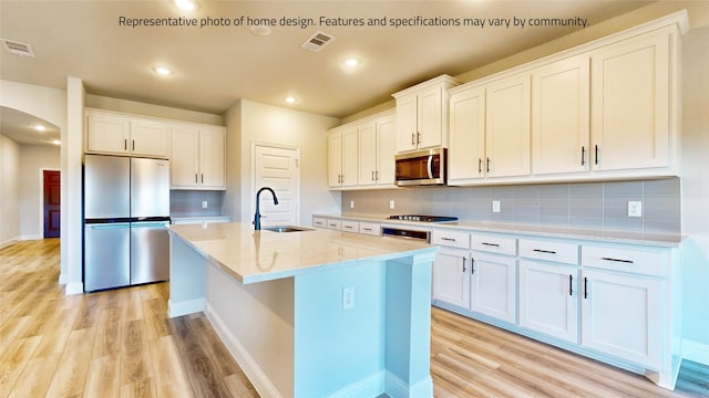 kitchen with tasteful backsplash, light hardwood / wood-style flooring, white cabinets, and stainless steel appliances