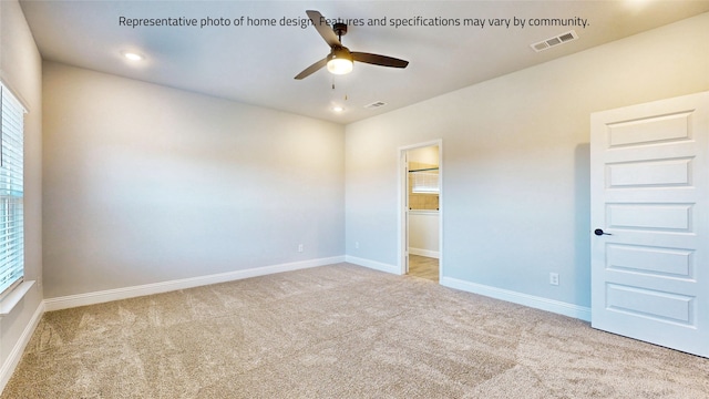 spare room with ceiling fan and light carpet