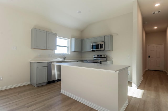 kitchen featuring sink, gray cabinetry, a center island, light wood-type flooring, and stainless steel appliances