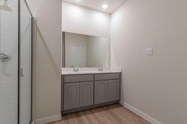 bathroom featuring hardwood / wood-style flooring, vanity, and walk in shower