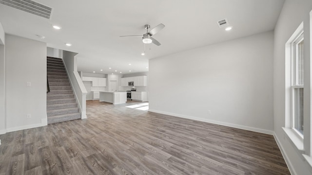 unfurnished living room with hardwood / wood-style flooring and ceiling fan