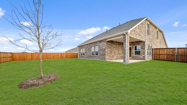 rear view of property with a yard and a patio area