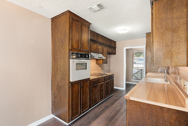 kitchen with white oven, black electric stovetop, sink, a textured ceiling, and dark hardwood / wood-style flooring