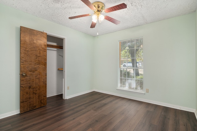 unfurnished bedroom featuring dark wood-type flooring, ceiling fan, a closet, and a textured ceiling