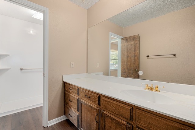 bathroom with vanity, hardwood / wood-style floors, and a textured ceiling