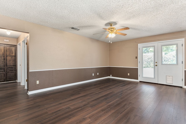 empty room featuring a textured ceiling, dark hardwood / wood-style floors, french doors, and ceiling fan