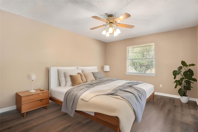 bedroom featuring dark wood-type flooring, ceiling fan, and a textured ceiling