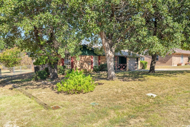 view of property hidden behind natural elements featuring a front lawn