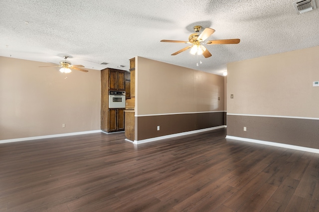 unfurnished room with ceiling fan, a textured ceiling, and dark hardwood / wood-style flooring